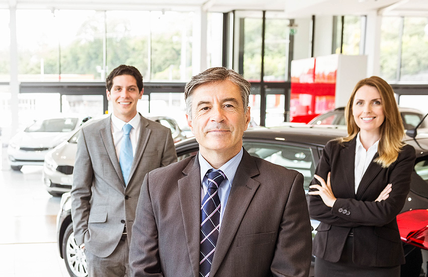 Sales team standing in a dealership.